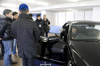 試乗前にドライビングポジションについて説明する、レーシングドライバーの松田晃司氏。