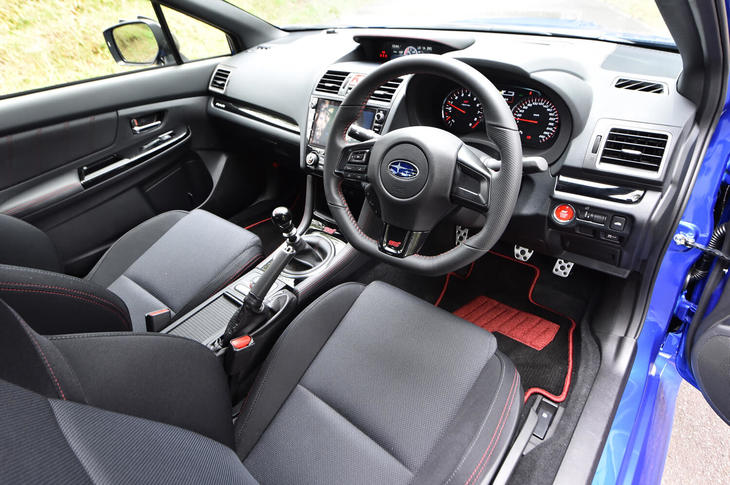 インテリアでは、グロスブラックの装飾パネルやドアトリムなどに用いられたレザー調の表皮素材、各所に施されたSTIのロゴが目を引く。