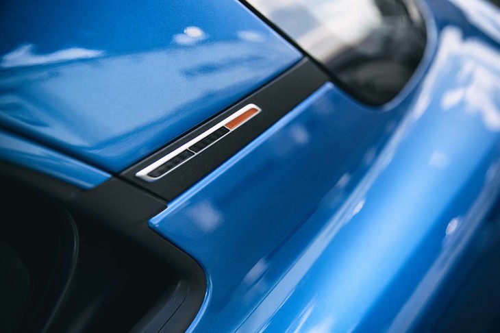 Cピラーのバッジもオレンジの差し色で飾られる（ほかの「A110」では青・白・赤のトリコロール）。同様の意匠はドアのインナーパネルにも見られる。