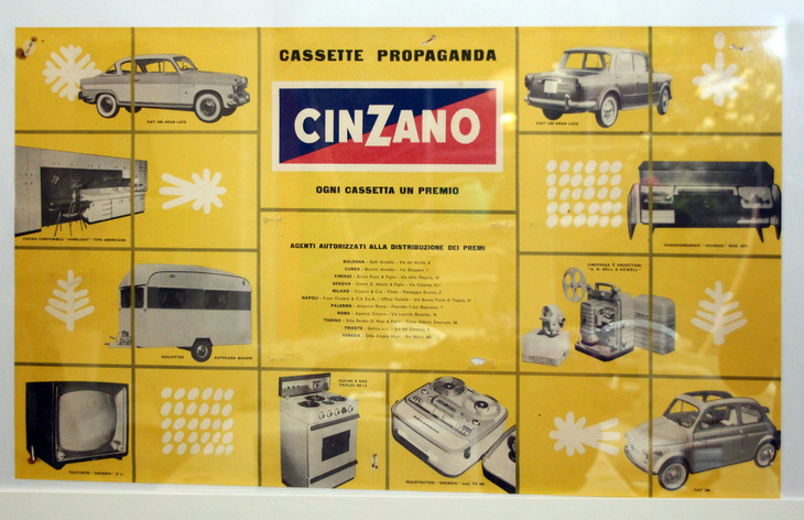 リビングルームの一角に貼られたベルモット酒「チンザーノ」の古い広告。フィアット各車をはじめとした懸賞の賞品が記されている。