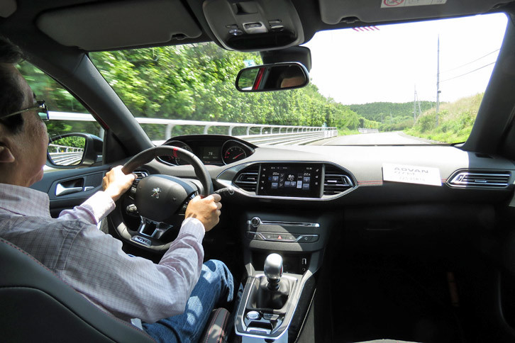 「アドバン フレバV701」が装着された「プジョー308GTiプジョースポール」に試乗する筆者。