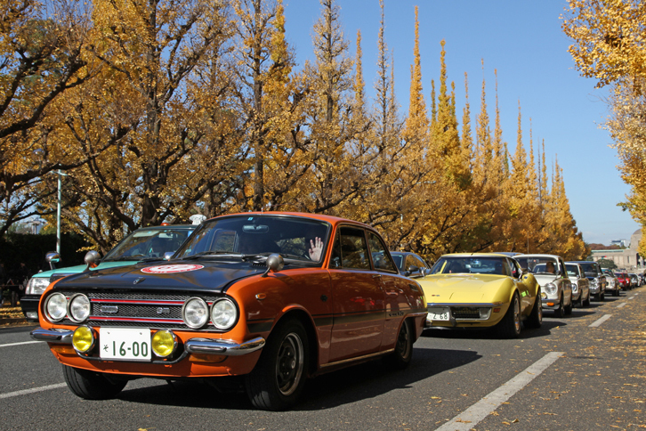 いちょう並木をパレード走行する参加車両。絵画館前から一度にまとまって出られるのは4、5台で、途中に信号もあるので、このように連なることはむずかしい。先頭は1970年「いすゞ・ベレット1600GTR」、2番目は1970年「シボレー・コルベット スティングレイ」。