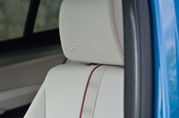 アイボリーホワイトのシートは、赤い差し色で飾られる。ヘッドレストには“X”ロゴのエンボス加工も。