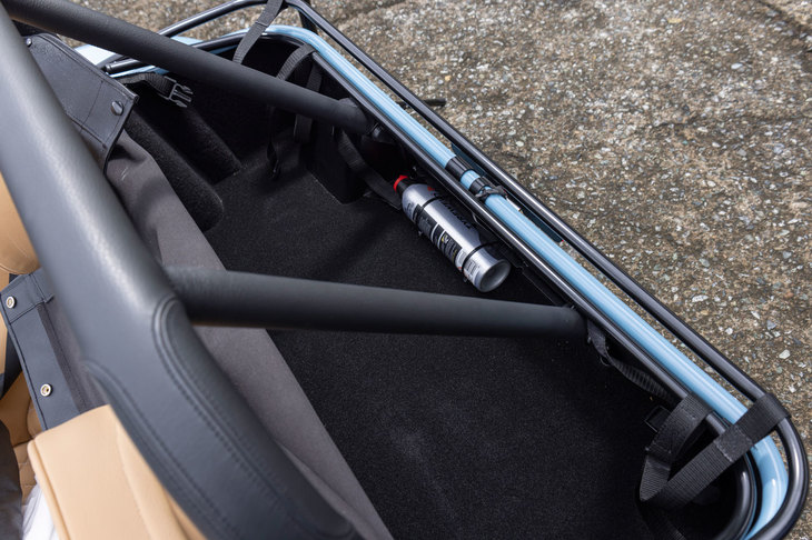 シートの後方には申し訳程度の収納スペースが。トノカバーはレザー調のソフト素材で、バチンバチンとボタンで閉めるシンプルなつくりとなっている。