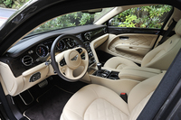 明るいベージュのレザーとダークブラウンのウッドパネルがふんだんにあしらわれたインテリア。ステアリングホイールにはシフトパドルが備わっている。