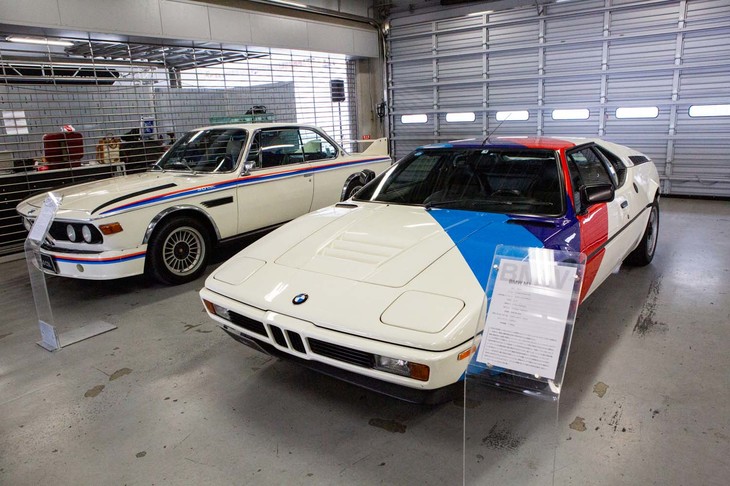 ピットに展示された1981年式の「BMW M1」（手前）と1973年式の「3.0CSL」（奥）。M1は「3.5CSL」のために開発された最高出力277psの3.5リッター直6エンジンをリアミドに搭載している。ボディーデザインはイタルデザイン率いるジョルジェット・ジウジアーロの手になるもので、ランボルギーニとの共同開発モデルでもあった。3.0CSLは、欧州ツーリングカー選手権に出場するためのホモロゲーションモデルで、「3.0CS」をベースに少数が生産された。車名末尾の“L”は、ドイツ語で“軽い”を意味する“Leicht”から付けられた。