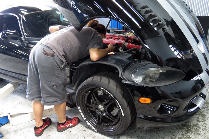 O2センサーへのアプローチ方法を探るメカニック氏。普通であればそんなに大変な作業ではないらしいが、記者の「バイパー」が改造車であるばかりに面倒をかけてしまった。