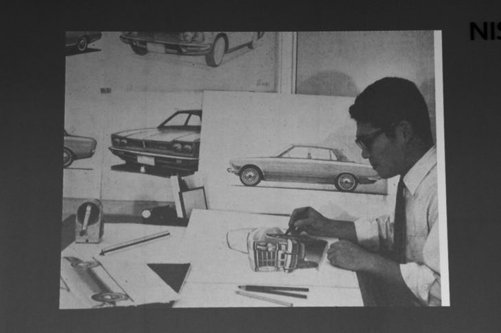 トークショーで公開された、初代「ローレル」のデザインスケッチを描く澁谷さん。本人によると、デザイン終了後に週刊誌の取材用に撮られた光景とのこと。