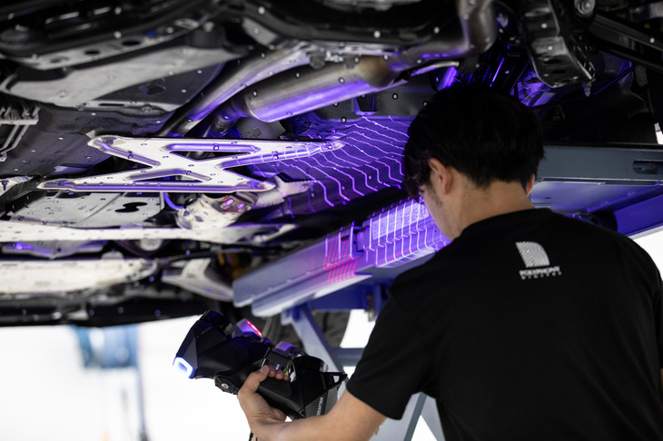 車両全体に丸いシールを貼り、スキャナーで緻密に形状を計測。その作業はインテリアやホイールハウス内、車両の底部にも及ぶ。
