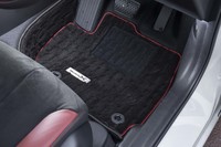 「ボルドーレッド」で縁取られたフロアマットも専用装備のひとつ。アルミ調の「Modulo X」プレートが付いている。