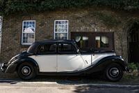 ガレージ（および住居）の壁はレンガを積み上げたもの。黄色いレンガは英国から取り寄せた。クルマは1952年のライレーRMBサルーン。今でも現役で、日常的に使われている。