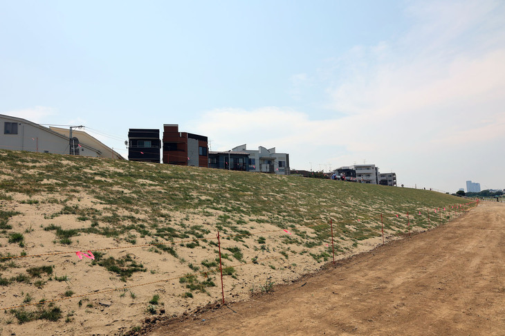 2022年7月、芝生養生のための囲いはあるものの、竣工した新堤防。法面が以前より急な角度になっている。