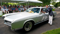 Eyes on Designでは過去のクルマのコンクール・デレガンス／デザイン・コンテストも行われるが、その受賞車、67年のビュイック・リビエラのオーナーに賞を授ける中村。