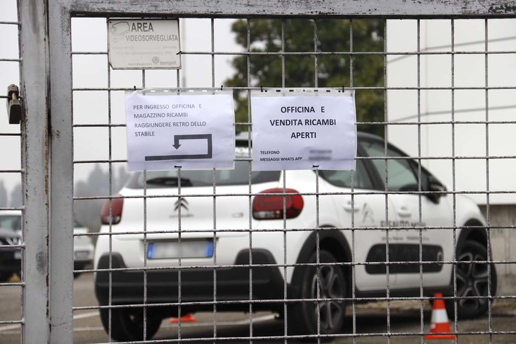 シトロエンの販売店。貼り紙には、部品販売コーナーと修理サービスは利用できることが記されおり、別の紙でそこまでの経路も示されている。