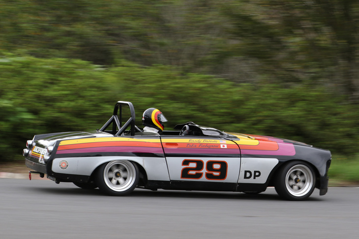 「ダットサン2000スポーツ」（SRL311）のレーシング仕様のサイドビュー。カラフルなカラーリングに合わせたドライバーのヘルメットがオシャレだ。U20型エンジンはインジェクション化されている。