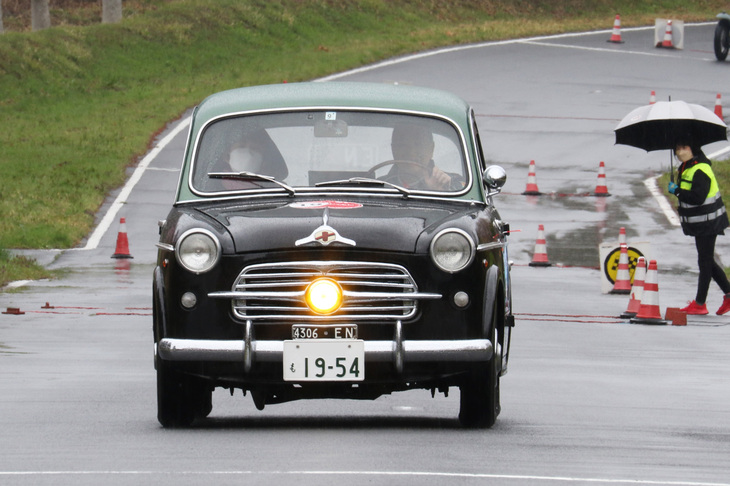 純正のフォグランプを灯（とも）して行く1954年「フィアット1100TV」。1100は戦前から1960年代までラインナップされたフィアットの代表的な小型ベルリーナ（セダン）。