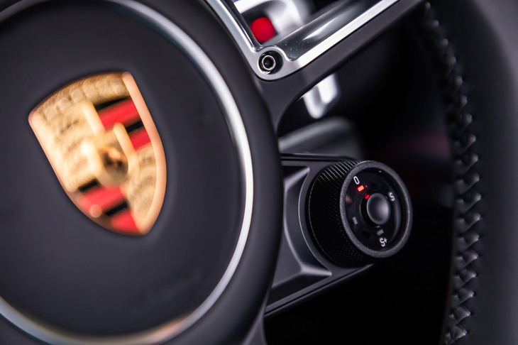 「718ケイマンT」に標準装備される「スポーツクロノパッケージ」の走行モード切り替え用ダイヤルが、ステアリングホイールの右下に備わる。
