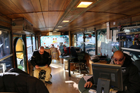 内部は木目調。写真の手前側が駐車場管理部門、奥のバーカウンターのようなテーブルがあるところが中古車部門。