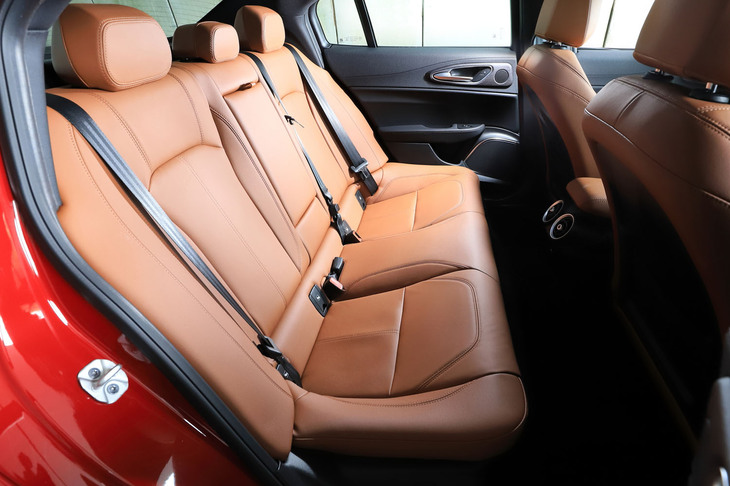 後席の乗車空間はDセグメントセダンとして標準的なもの。フロントセンターコンソールの背面にはエアコン吹き出し口が、センターアームレストには2つのドリンクホルダーが備わる。