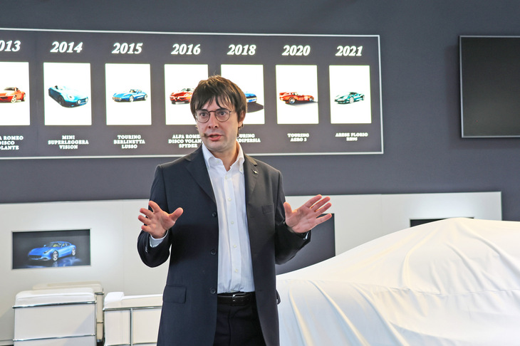 歴代トゥーリング製モデルの写真を背景に語る、デザインダイレクターのマッテオ・ジェンティーレ氏。