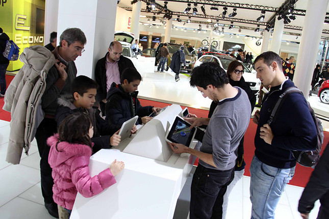 フォルクスワーゲンのシミュレーションゲームを、用意されたiPadで楽しむ来場者たち。2010年12月、ボローニャモーターショーで。