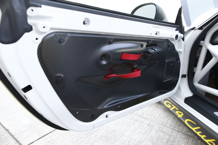 ドアトリムはカーボン製。ドアノブはレーシングポルシェ伝統のストラップ式。
