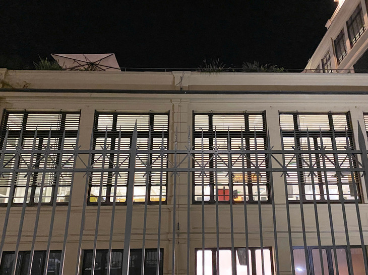 裏に回る。こちらからもネオンが。途中階のテラスには、パラソルが広げられている。