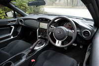 「R」のインテリア。装着されるスポーツインテリアパッケージ（オプション）は、本革巻きステアリングホイールやハンドブレーキレバー、シフトブーツに赤いステッチが施され、アルミパッド付きスポーツペダル、シルバー加飾、ステンレス製サイドシルプレートが装備される。カーナビはディーラーオプション。