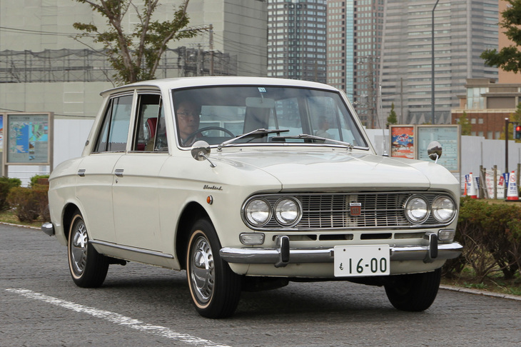1965年「ダットサン・ブルーバード1600SSS」。ブルーバードのスポーティーグレードの名称である“SSS”を最初に冠したモデル。純正キャップ付きのスチールホイールにホワイトリボンタイヤと、オリジナルの姿を守っている。
