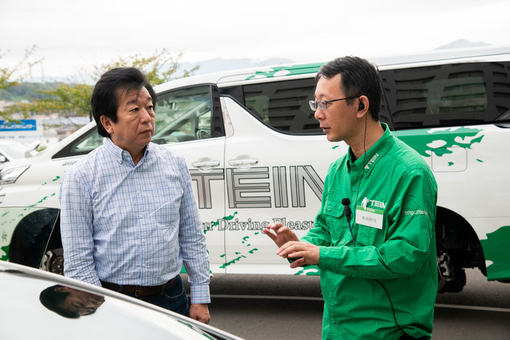 車種ごとの「EDFC」の取り付け可否について、テインのスタッフに理由を質問する筆者（写真左）。