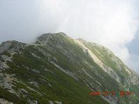 稜線づたいを眺めると、斜面の岩や小石がいまも移動している（下に転がっている）部分と、そうでない部分がはっきりわかる。既に移動しなくなった部分には植物が入り込み、緑の地帯をつくりだしている。