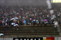 降り続く雨の中、グランドスタンドのファンが予選を見守る。