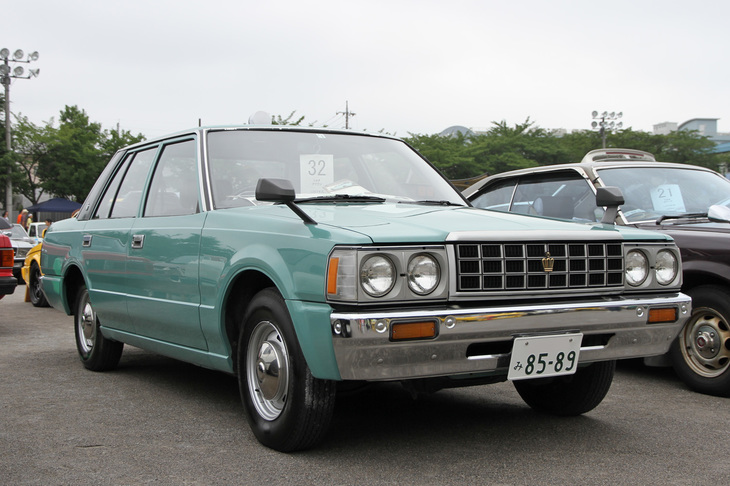 1987年「トヨタ・クラウン スタンダード」。「いつかはクラウン」のキャッチフレーズで知られる7代目クラウン セダン（120系）の、タクシー風コスプレ（改造）かと思いきや、LPGエンジンを搭載したホンモノの営業車仕様だった。
