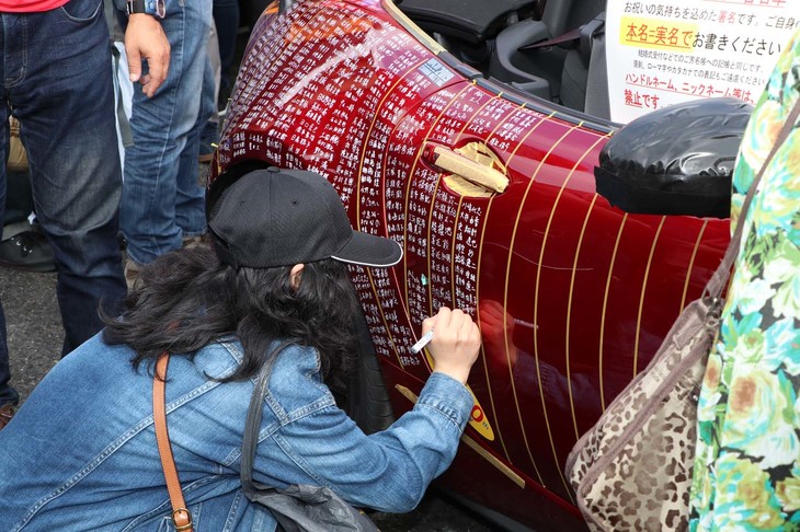 30周年記念サイン車に、サインするファン。誰もが感謝の気持ちを込めるように、丁寧にサインをしている姿が印象的であった。