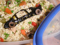 社長の写真への返礼として、かつてわが女房がノリとオリーブ、ケイパーで制作した「1968年イタルデザイン・ビッザリーニ・マンタ弁当」を送信しておいた。筆者撮影。