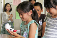 「キロボ ミニ」に話しかける生徒たち。キロボは人とのコミュニケーションによってさまざまな言葉を覚え、新しい会話ができるようになるという。