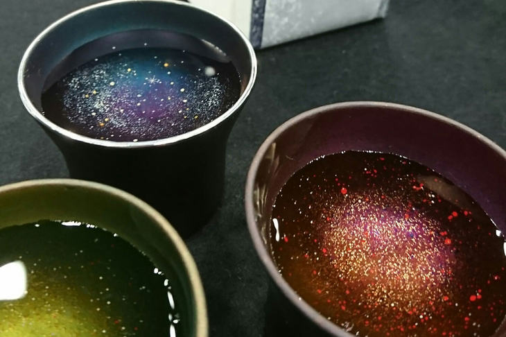 佐藤さんの作品「宙COCORO」シリーズ。小さいサイズの猪口（ちょこ）と大きいサイズのタンブラーの2種類を用意。器は長岡市のササゲ工業とのコラボ作品で、特殊加工によりステンレス皮膜を厚くすることで光の屈折率を変化させ、色が変わって見えるよう仕上げている。（写真＝佐藤裕美）