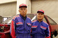 斉藤忠夫氏（写真左）は、長年レーシングマシンのチューニングやDOHCエンジンの整備に携わったトヨタの名匠。「トヨタ2000GT」のスペシャリストでもある。亀田明氏（写真右）は、トヨタ内での板金作業のインストラクターを務めていた、板金のマエストロだ。