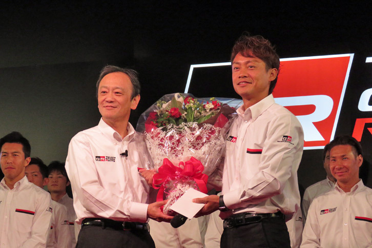 SUPER GT GT500クラスのドライバーを引退し、チーム・ルマンの監督に就任した脇阪寿一氏（右）と、脇阪氏に花束を贈るトヨタの伊勢清貴専務。