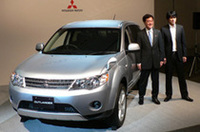 三菱自動車工業の益子修取締役社長（左）と、TVCFに起用された江口洋介さん。