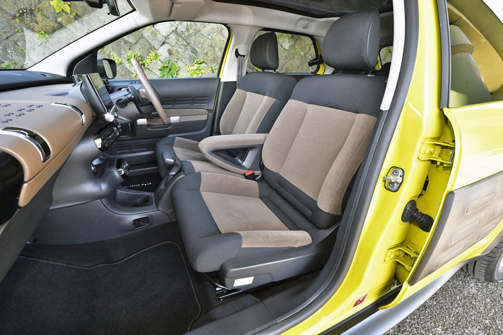 左右がつながったベンチシート風デザインの前席（2人用）。中央にアームレストが備わる。