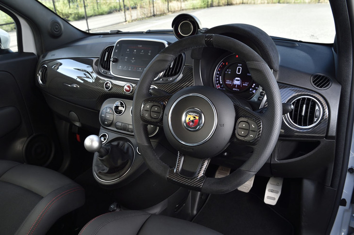 インレイにカーボンを用いたレザーとアルカンターラのコンビネーション仕上げとなる、スポーツステアリングホイールを装着。