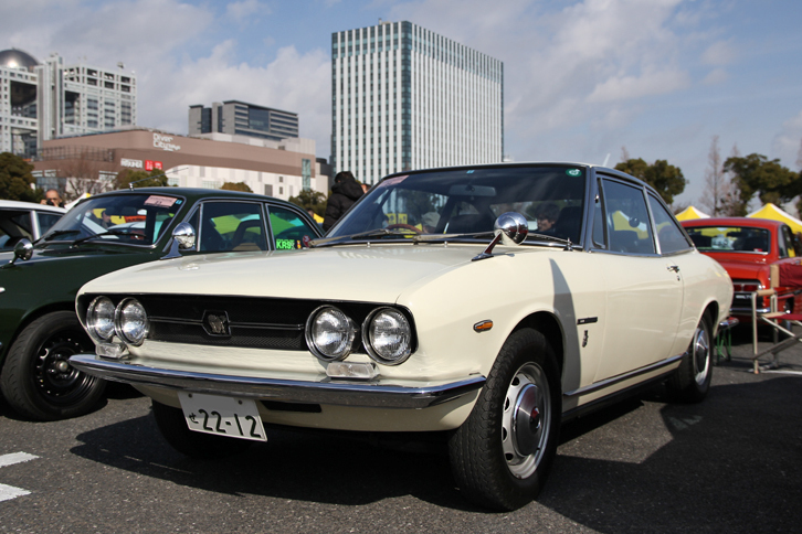 1969年「いすゞ117クーペ」。1968年末のデビューから1973年春までの、いわゆるハンドメイド時代の最初期型となる個体で、フルオリジナルの姿を保っている。1.6リッター直4 DOHCエンジンを搭載。コンクールデレガンスでベストエレガンス賞を受賞した。