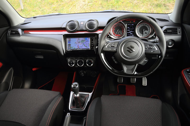 赤から黒にグラデーションする、個性的な意匠の装飾パネルが目を引くインテリア。本革巻きのステアリングホイールは、表皮にディンプル加工を施すことでグリップ性を向上させた専用品となっている。