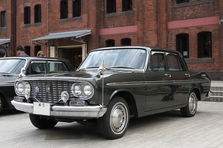 「トヨペット・クラウン デラックス」。1962年にデビューした2代目クラウンの初期型の高級グレード（当時は「スタンダード」とデラックスしかなかったが）。新車以来とおぼしき「栃5」のシングルナンバー付きのトヨグライド（2段AT）仕様で、内外装もオリジナルを保っている。