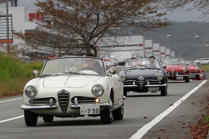 メイン会場であるCパドックに向かって富士スピードウェイ内を連なって行く、ピニンファリーナ製ボディーを持つ初代「ジュリエッタ」（1300cc）および「ジュリア」（1600cc）の「スパイダー」。