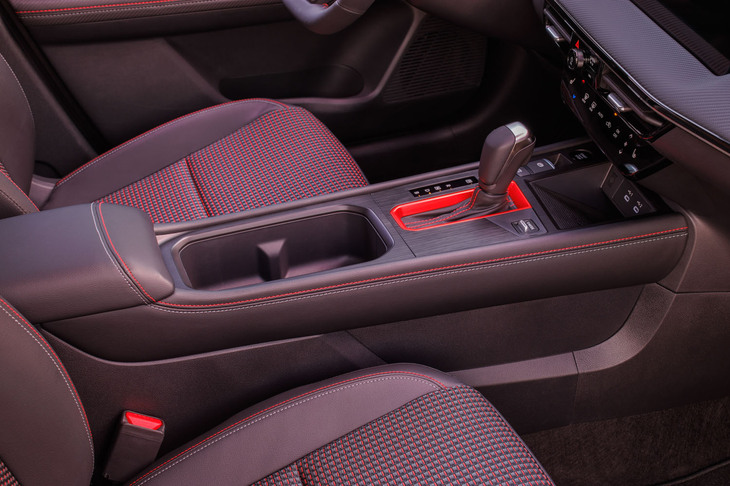 ワイヤレス充電システムが装備される、最上級グレード「キックスSR」のインテリア。ツートンカラーのステッチやシフトレバーの周囲に赤い差し色を用いるなどしてスポーティーに仕上げられている。