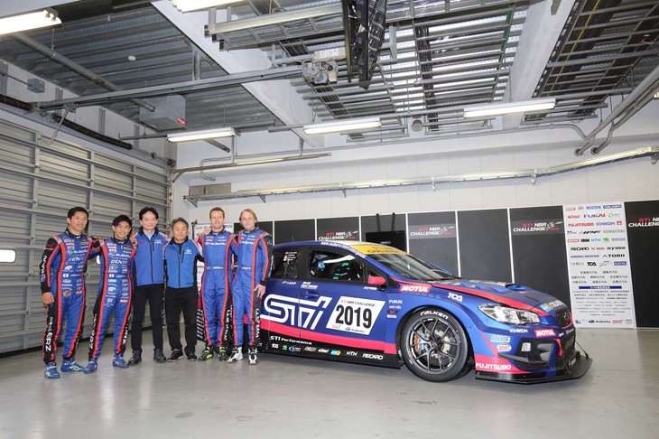 シェイクダウンテスト直前に報道陣に披露された2019年型「スバルWRX STI」。ニュルブルクリンク24時間レースで連覇を期する同車の前で記念撮影に臨むのは、左から山内英輝選手、井口卓人選手、STI平川良夫社長、辰己英治STIニュルブルクリンク24時間レース総監督、カルロ・ヴァン・ダム選手、ティム・シュリック選手。空気を整流し抵抗を減らすため、ボディー全体にマット塗装が施されたマシンは高い質感を誇る。ちなみに、フロントフェンダールーバーとドアミラーには表面の凹凸を大きくした「サメ肌塗装」が用いられている。