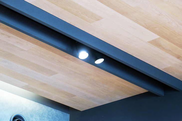 ショールームの天井は、あえてビルの内部であることをアピールすよう梁（はり）を強調したデザインに。また、目立たぬようその梁の内側に照明を設けるなど、細かいところまでデザイナーのこだわりが込められている。