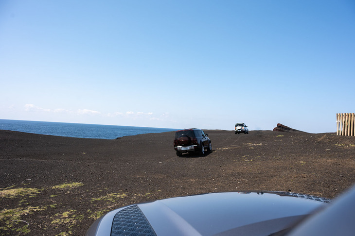 砂浜を横切り、新鼻新山（写真左奥）へと向かう「ディフェンダー」の車列。新鼻新山は1983年の噴火により、一夜でできたという火砕丘だ。